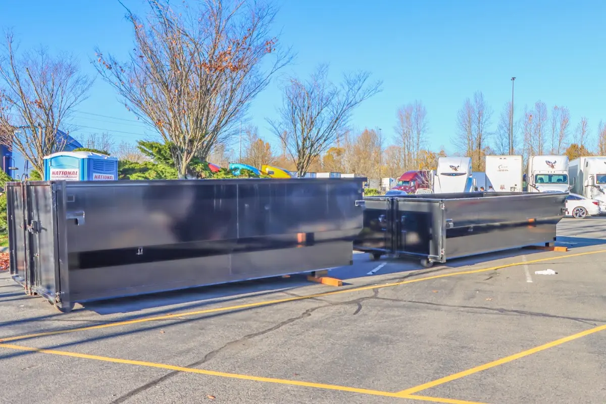 Professional dumpster rental service with roll-off container on residential driveway in Georges